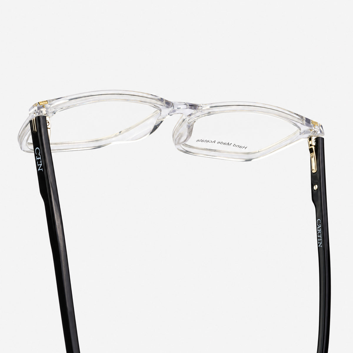 Vista inferior de bisagras y refuerzos metalicos en montura de acetato transparente Piclek