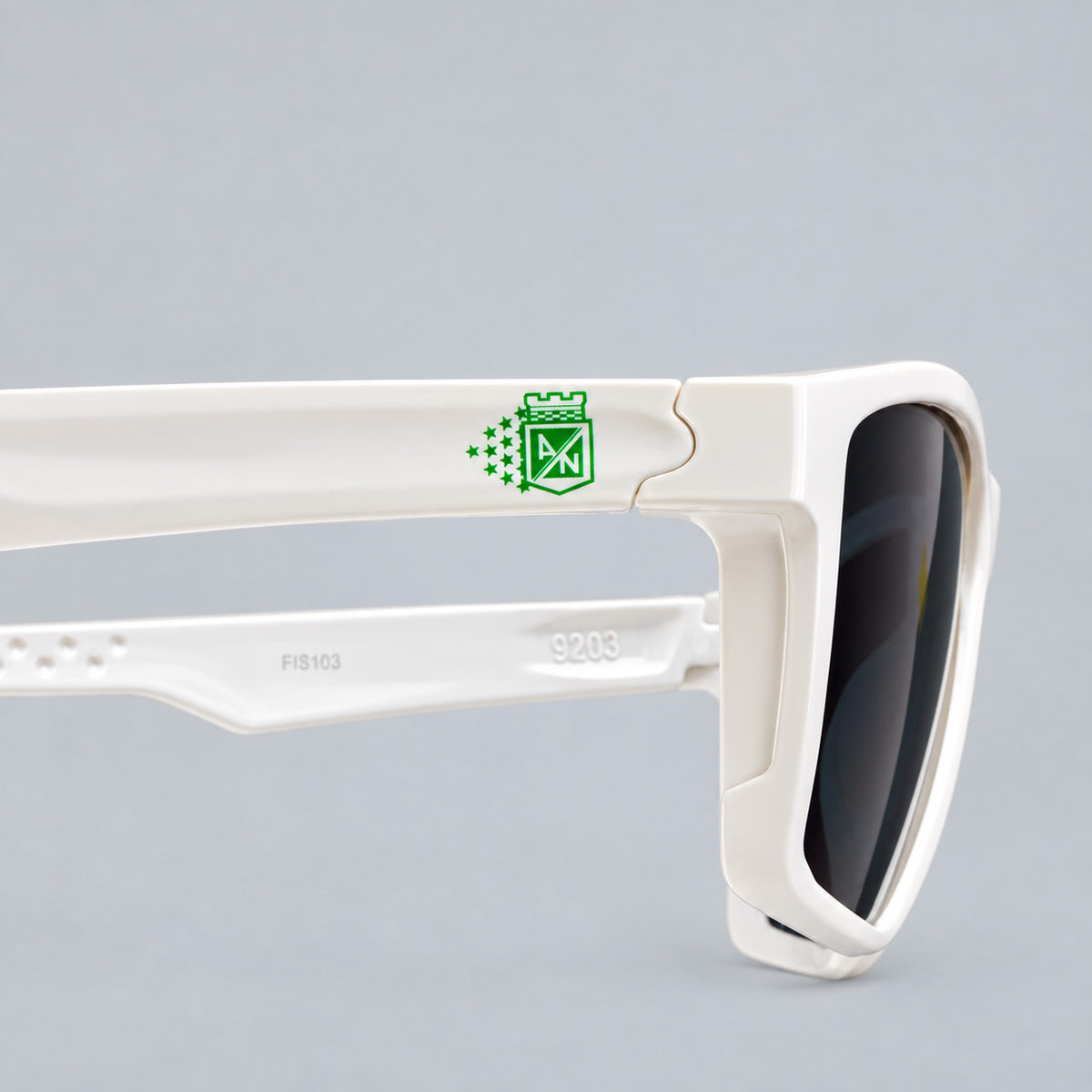 Detalle en primer plano del escudo verde con estrellas de Atletico Nacional en varilla de gafa blanca Piclek